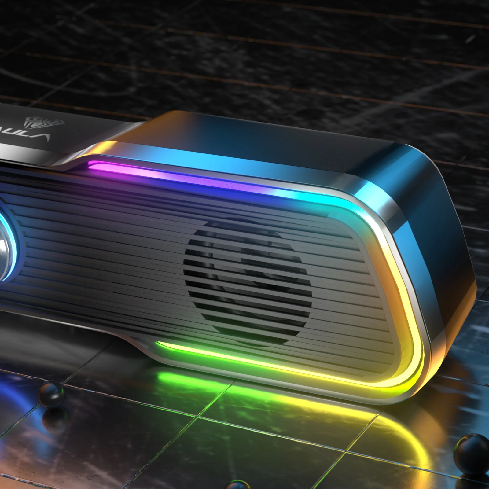Крупный план светящейся RGB-ленты и решётки динамика AULA N-169B на тёмном столе