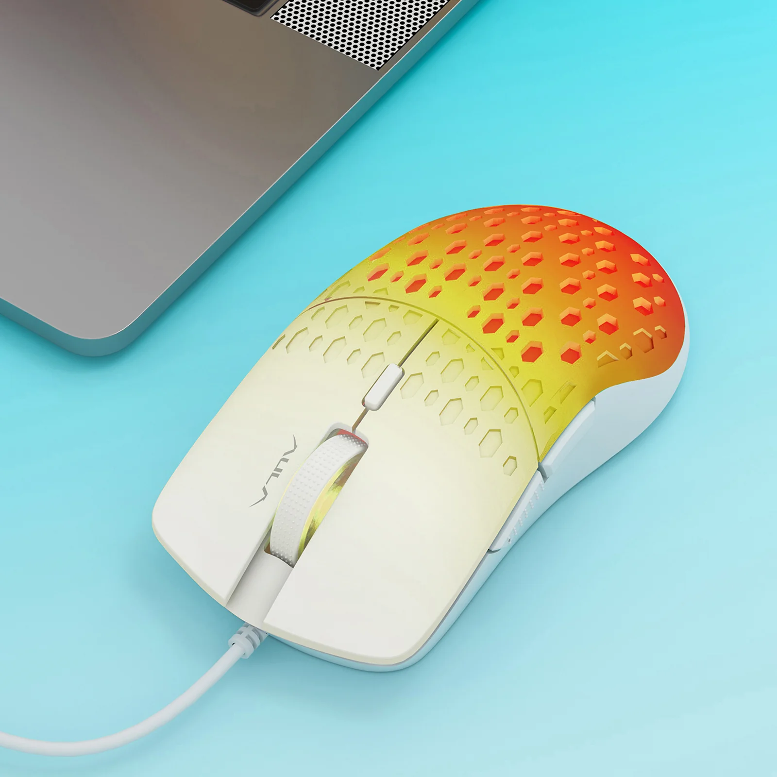 Белая AULA S11 Pro рядом с ноутбуком: сотовый рельеф корпуса и тёплая подсветка