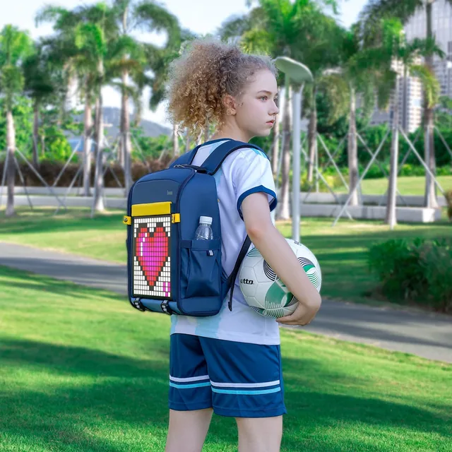 Школьница в парке с синим рюкзаком Divoom Backpack-S, на экране пиксельное сердце