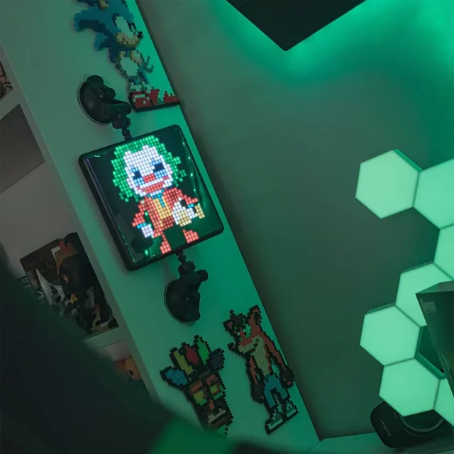 Divoom Pixoo-Max на стене игровой комнаты рядом с подсветкой и фигурками