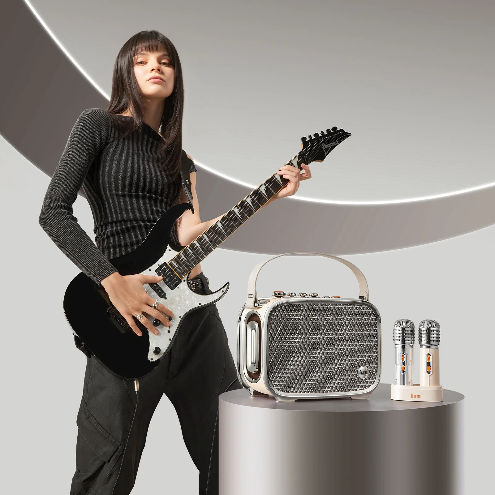 Divoom SongBird-Ultra with its microphones on a plinth beside a guitarist holding an electric guitar