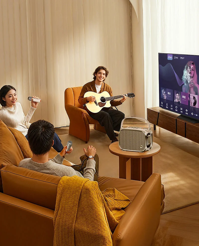 Divoom SongBird-Ultra on a living-room table with karaoke on the TV, microphones and a guitar