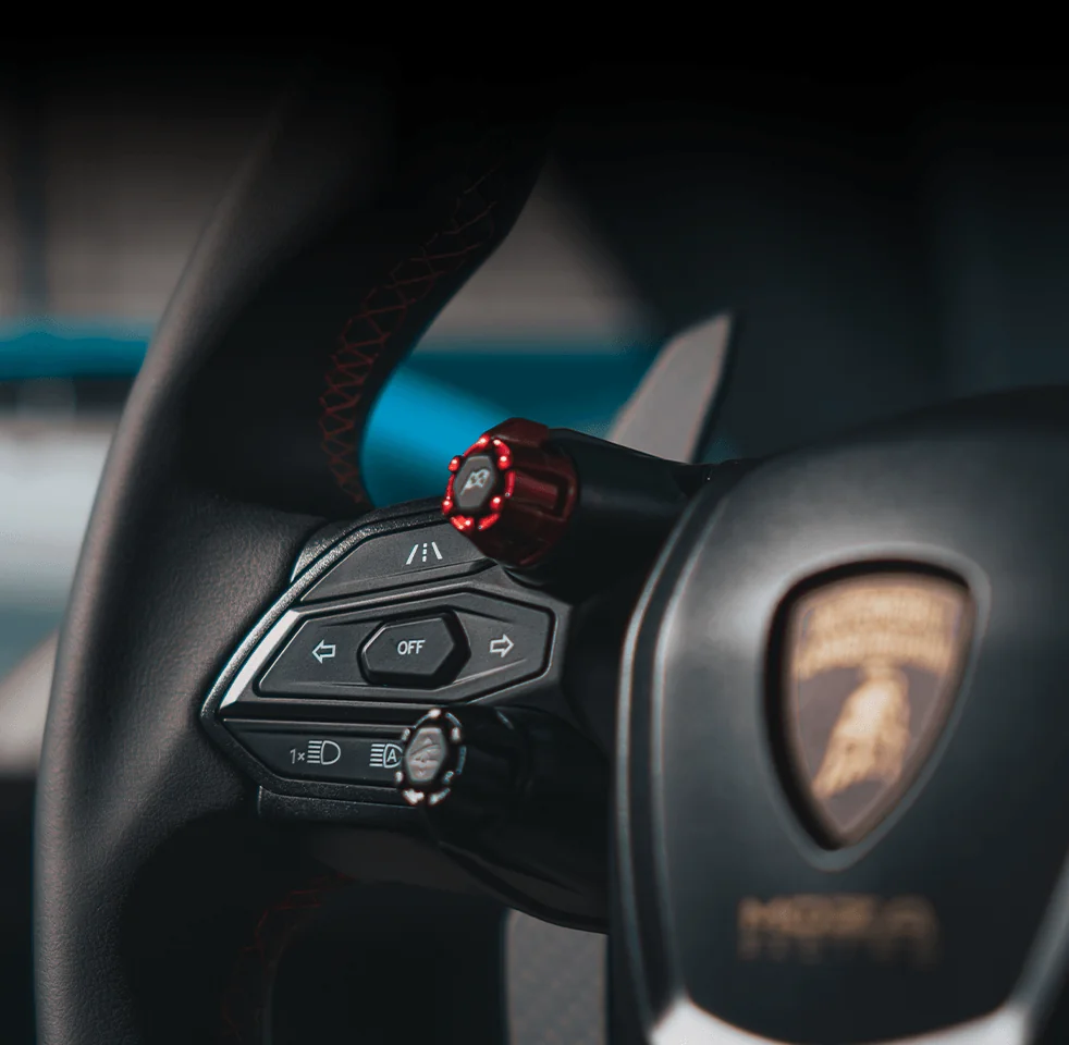 Крупный план клавиш режимов и щитка Lamborghini на руле MOZA Revuelto